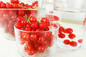Johannisbeeren - Beeren der Saison in Schale und in Karaffe mit Wasser