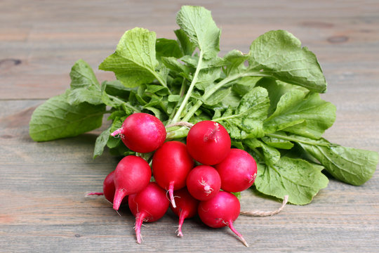 A bunch of radishes  on a  brown wooden table