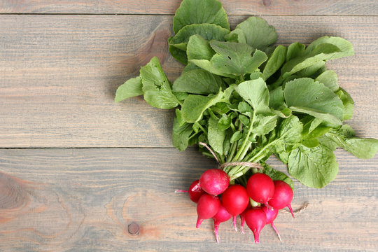 A bunch of radishes  on a  brown wooden table