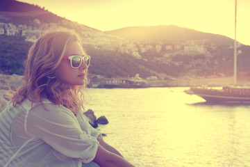 Girl on the seashore watching the sunset