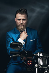 Obraz na płótnie Canvas Handsome businessman on a motorbike
