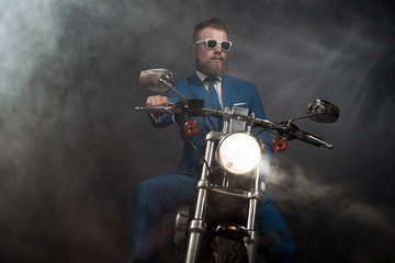 Obraz na płótnie Canvas Trendy businessman on a motorbike