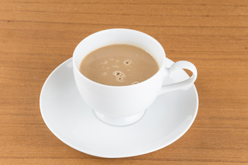 a cup of coffee on wood table