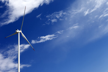 Wind turbine and blue sky with clouds