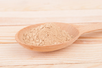 Nutmeg in a spoon on a wooden table.