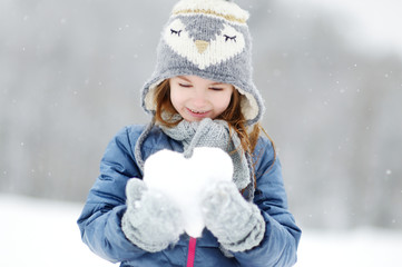Funny little girl having fun in winter park