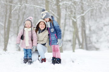 Fototapeta na wymiar Young mother and her two daughters on winter