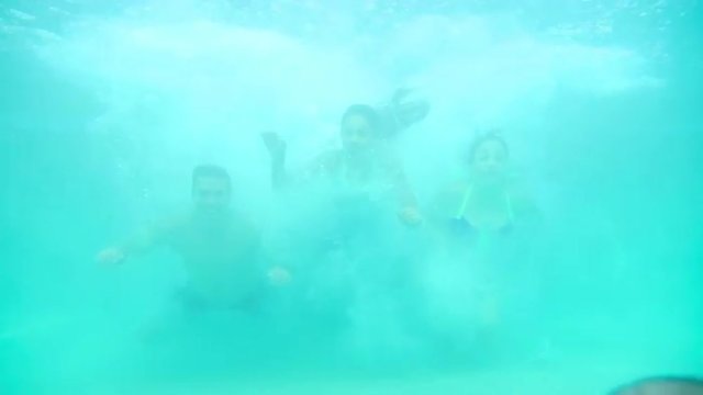 Hispanic family jumps into a pool together