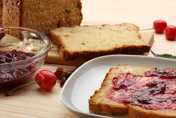 Sweet bread  with raisins and almonds, butter and cherry jam