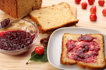 Sweet bread  with raisins and almonds, butter and cherry jam
