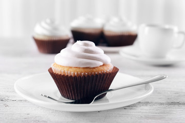 Delicious cupcakes on table on light background
