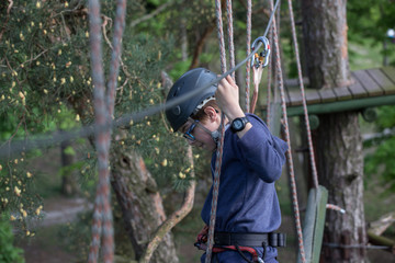 teenager climbing a rope park, Girl climbing in adventure park  