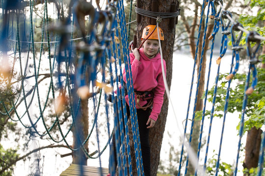 teenager climbing a rope park, Girl climbing in adventure park  