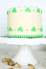 Tasty cake for St Patrick Day on table on brick wall background