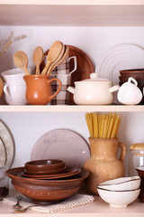 Fototapeta na wymiar Kitchen utensils and tableware on wooden shelves