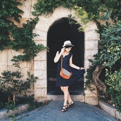 young beautiful woman in a straw hat posing in a park