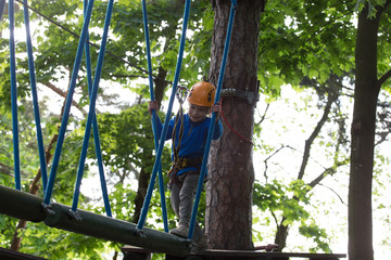 Naklejka na ściany i meble boy climbing a rope park, Girl climbing in adventure park 