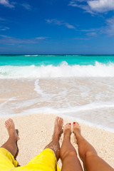Male and female legs on tropical beach