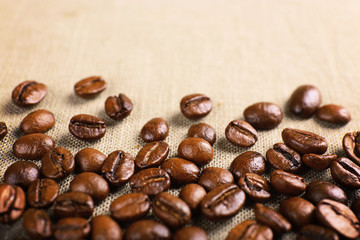 Frame of coffee beans on color sackcloth background