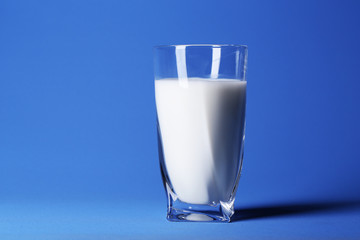 Glass of milk on blue background