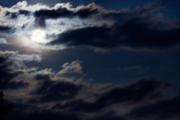 Fototapeta premium full moon through a frightening storm clouds