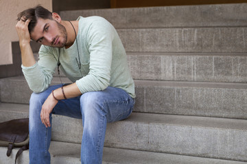 Casual  young man sitting on steps