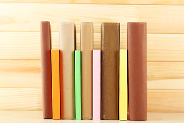 Books on shelf, close-up, on wooden background