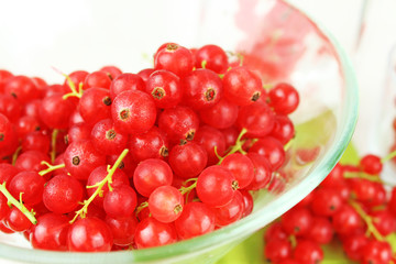 Johannisbeeren in Schale aus Glas und auf Esstisch auf grüner Serviette