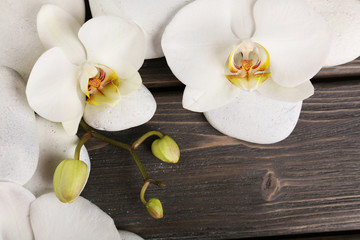 Naklejka na ściany i meble Spa stones and orchid flower on wooden background