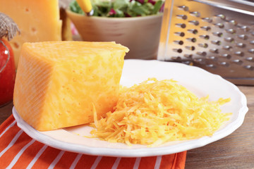 Grated cheese on wooden table, closeup