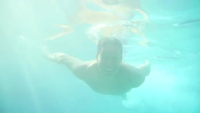Hispanic man waves underwater