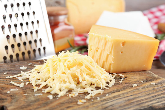 Grated cheese on wooden cutting board, closeup