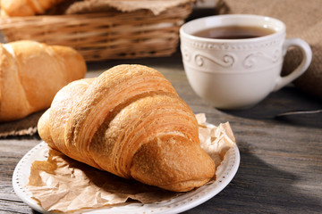 Delicious croissants on plate on table close-up