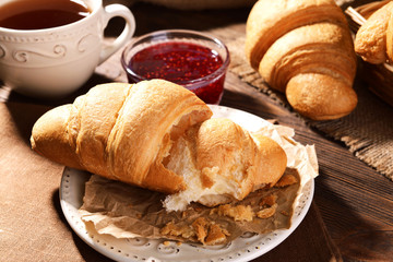Delicious croissants on plate on table close-up