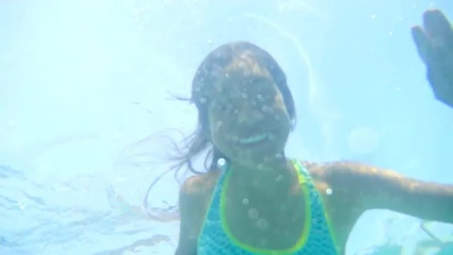 Young Hispanic Girl waves underwater