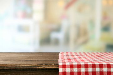 Empty wooden table with napkin and light background