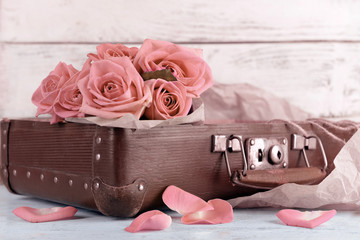 Beautiful pink roses in suitcase, closeup