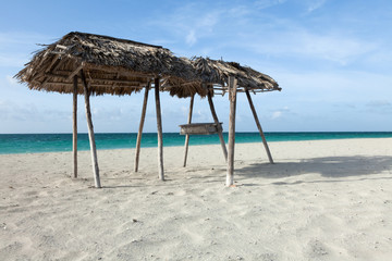 A lone sun umbrella stands on the beach.