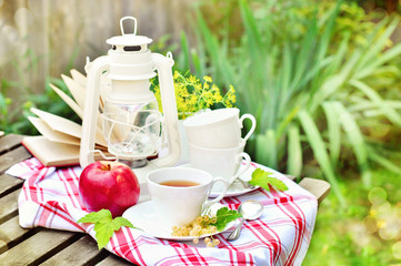 A cup of tea with currents on a terrace, vintage objects, outdoors, selective focus