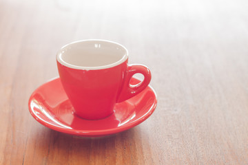 Red coffee cup on wooden table