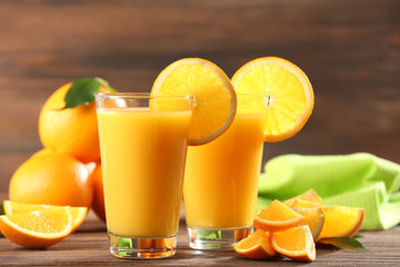 Orange juice on table on wooden background
