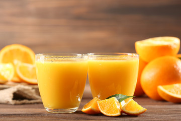 Orange juice on table on wooden background