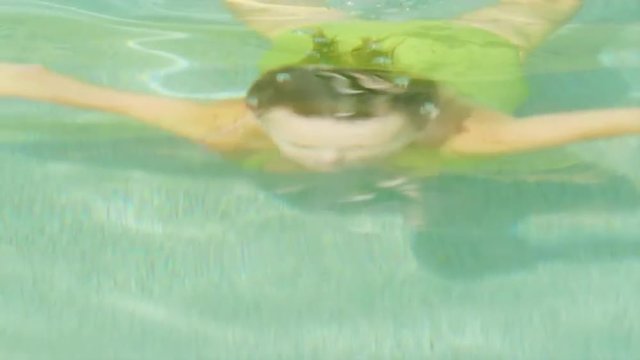 Woman emerges from water in a pool