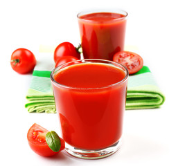 Glasses of fresh tomato juice on checkered napkin, isolated on white