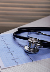 Cardiogram with stethoscope on table, closeup