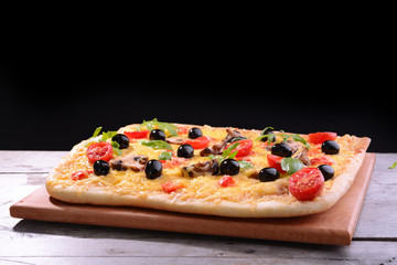 Delicious homemade pizza on table on black background