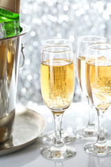 Glasses of champagne on bright background
