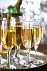 Glasses of champagne on bright background