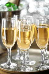 Glasses of champagne on bright background