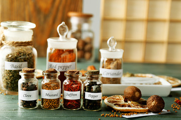 Assortment of spices in glass bottles on wooden background